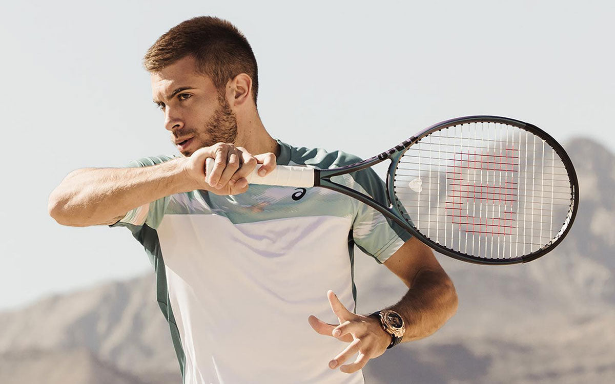 Un ragazzo gioca a tennis con una racchetta Wilson