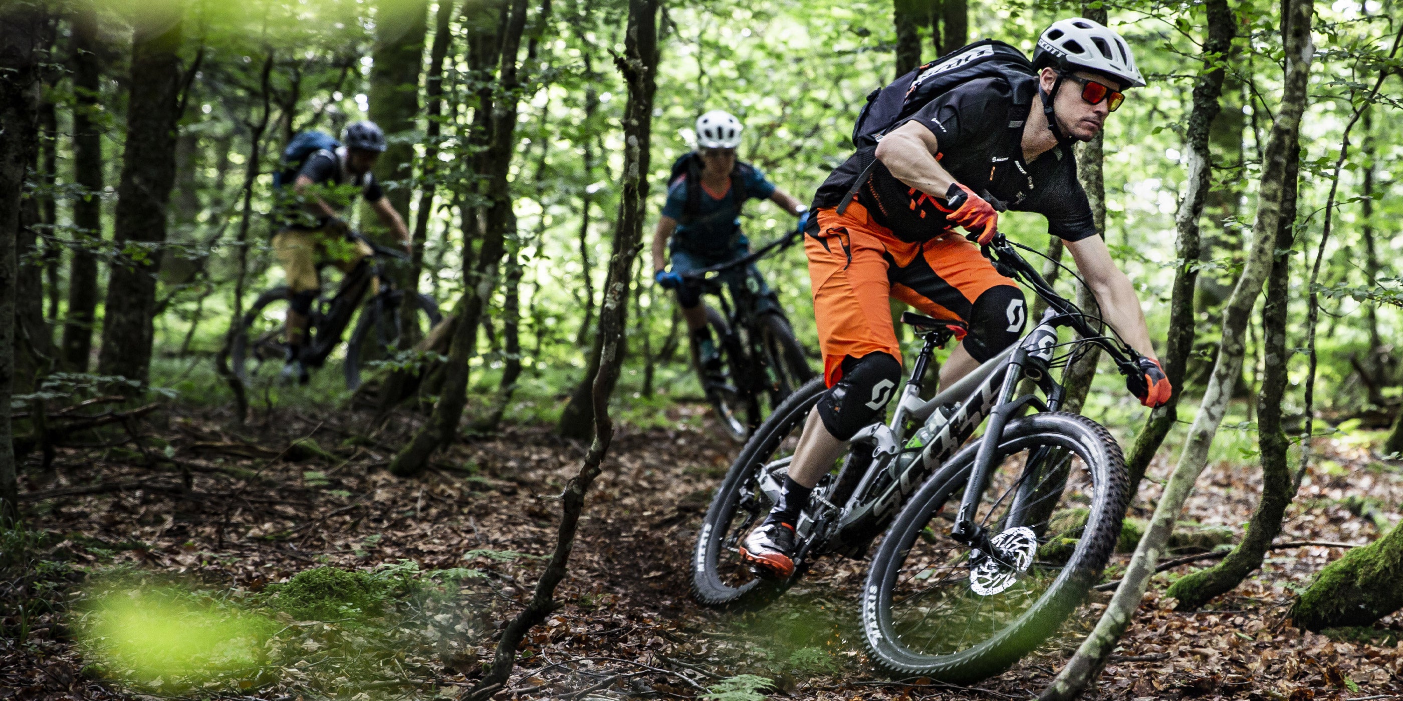 Scott - Gruppo di ragazzi pedala nei boschi in mountain bike